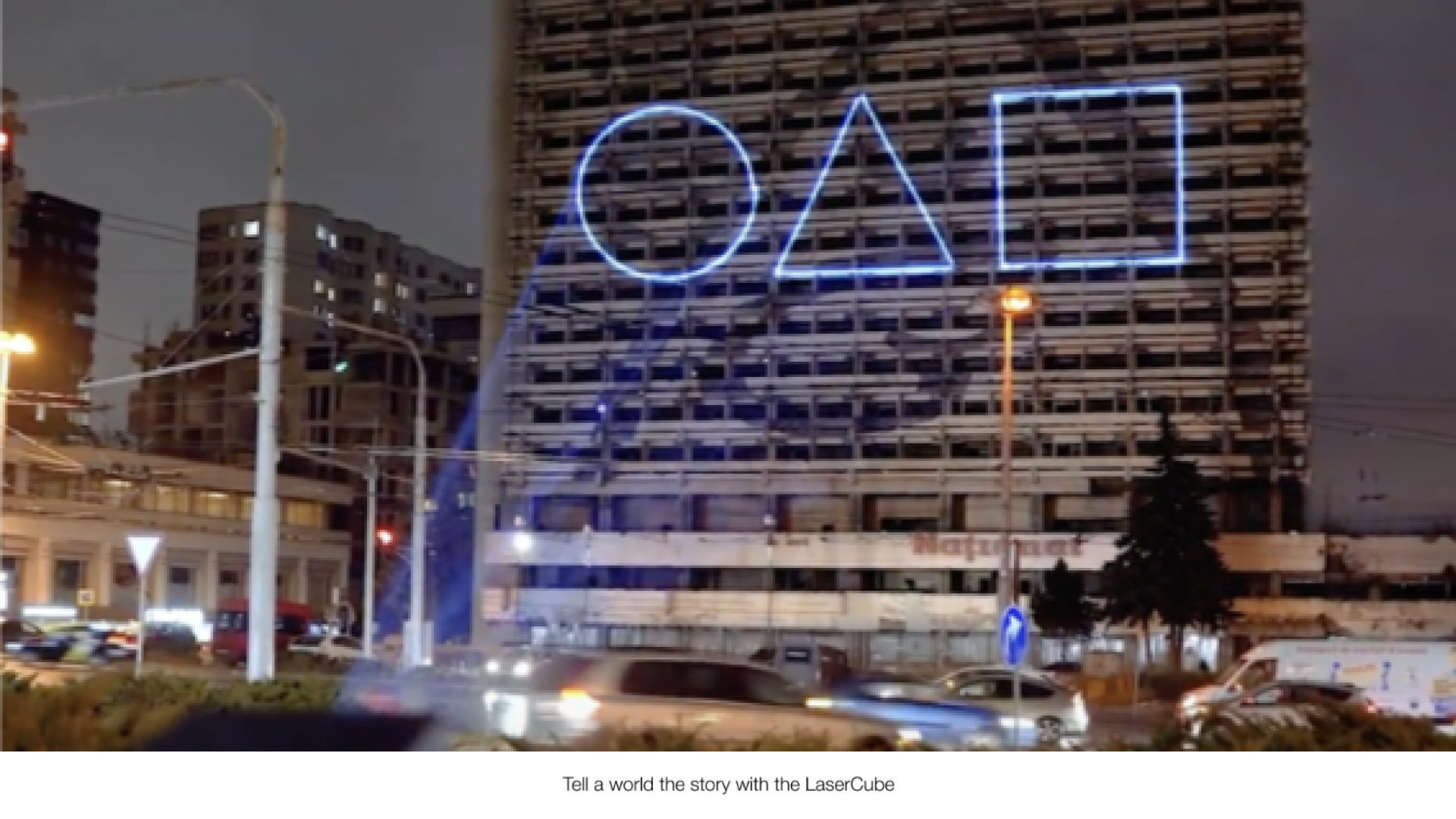 cube2 Laser lights being shown in an outdoor laser advertising environment, projecting blue laser lights from a laser cube on the road.