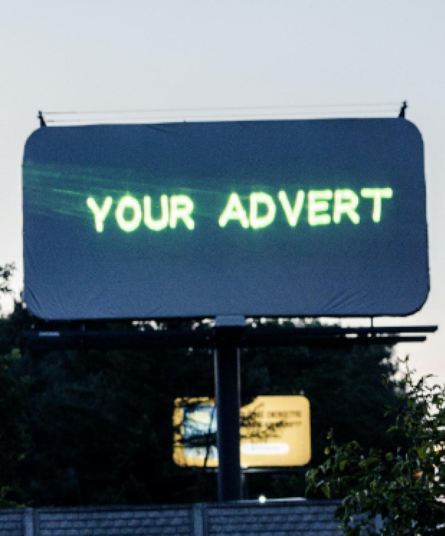 mob-img A blank outdoor billboard with the text "your advert" projected onto it from a Lasercube laser projector, showcasing how it can be used for outdoor advertising