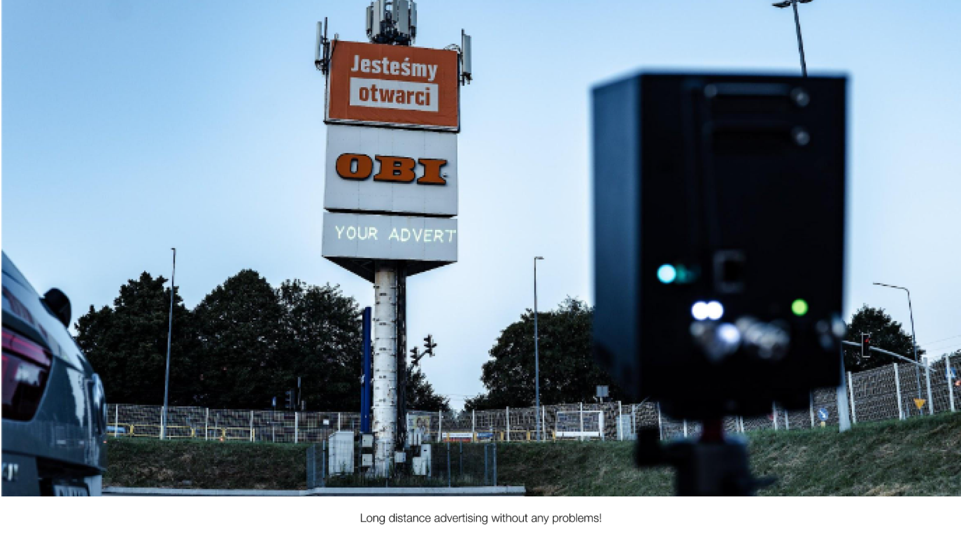 obi A large signage outdoor with the text "your advert" projected onto it from a Lasercube laser projector, showcasing how it can be used for outdoor advertising