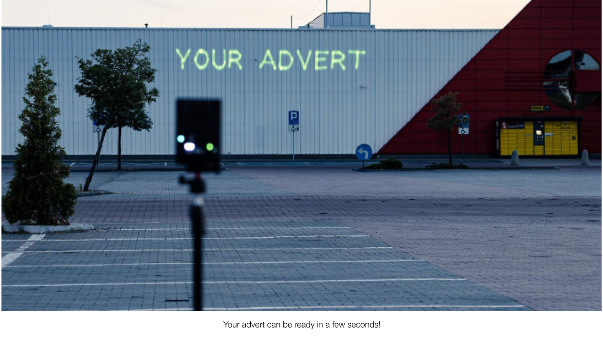 sec A small white building with the text "your advert" projected onto it from a Lasercube laser projector, showcasing how it can be used for outdoor advertising