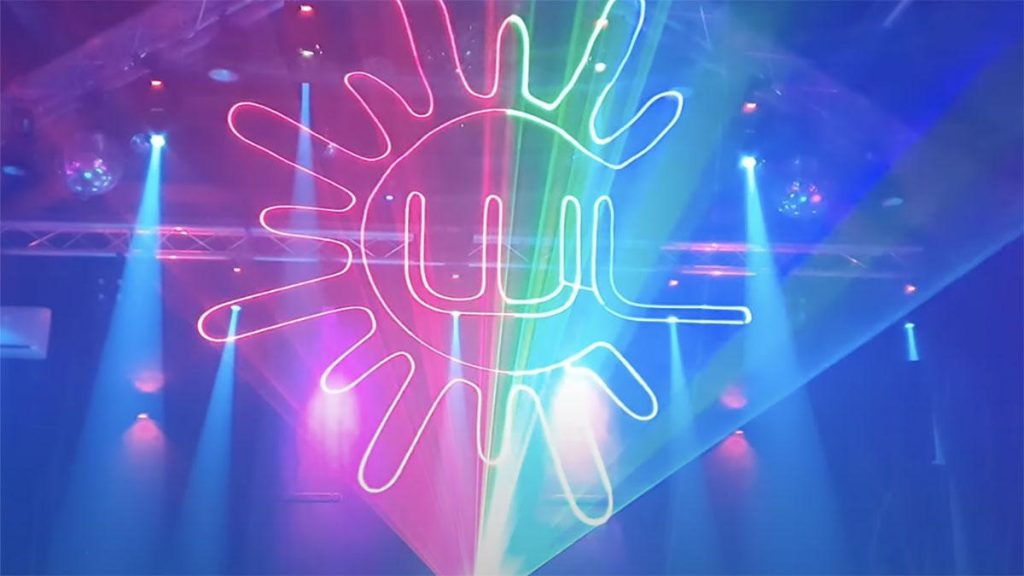 7 Laser projection through smoke on a stage showing green and red laser lights, with the Wicked Laser logo.